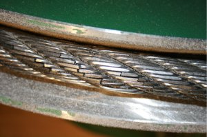 On constate le bris de brins d’acier dans les torons d’un câble de traction. Les métaux composant les câbles d’acier sont soumis à des cycles de déformation ce qui va naturellement entraîner le bris des brins d’acier, autrement dit, les câbles d’acier ont une certaine durée de vie et doivent être inspectés régulièrement. Dans ce cas particulier, outre l’arrêt de la ligne de production, le bris du câble aurait pu engendrer un problème de santé & sécurité.
